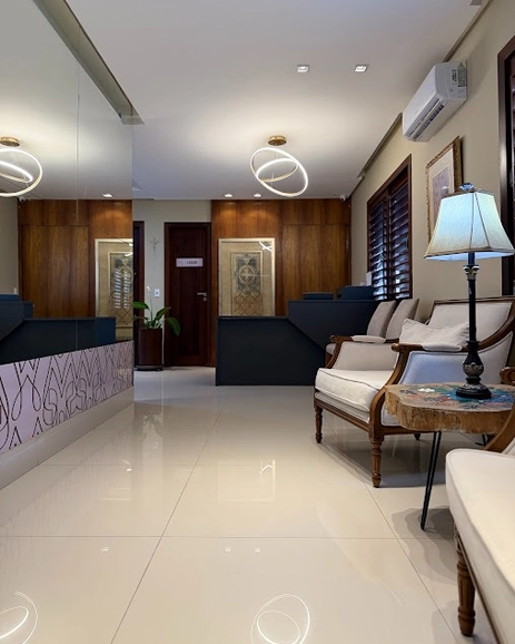 Cantos acolhedores da Casa Movitare: poltrona, plantas e luz natural quente.