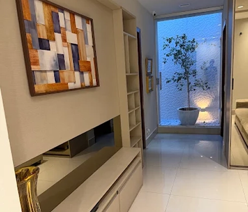Sala de atendimento serena, com parede verde-sálvia e luz natural suave.