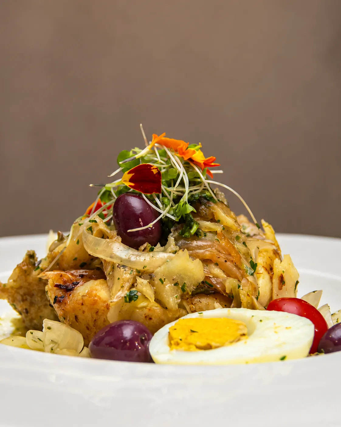 Bacalhau à lagareiro com batatas, alho e azeitonas em composição clara